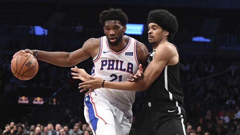 Joel Embiid drives the ball while being defended by Brooklyn centre Jarrett Allen.