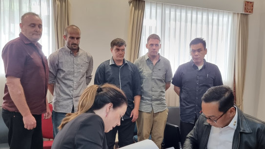Martin Stephens, Micahel Cjugaz, Scott Rush, Matthew Norman and Si Yi Chen look on as Australia and Indonesia sign an agreement for their return home.