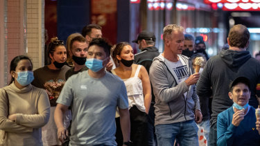 People queuing for gelato in Melbourne's east with their face masks over their chins. 