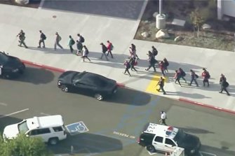 People are led out of Saugus High School in the city of Santa Clarita.