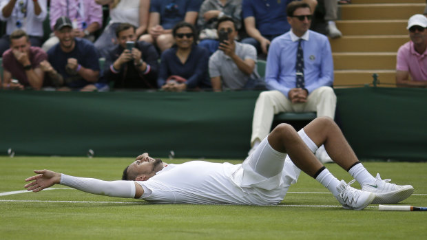 Kyrgios lays on the court after diving for a shot against Thompson.