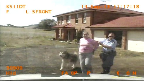 Lytha Owlstara is handcuffed and led away from her home during the incident in September 2013.