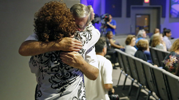 Dennis Padgett embraces Sandra Deadwyler during a vigil for the victims of the mass shooting.