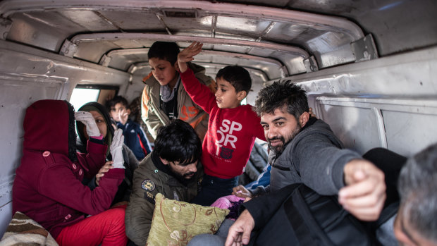 Refugees and migrants sit in the back of a van as they prepare to head to the shores of the Evros river to attempt to enter Greece from Turkey.