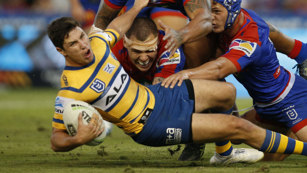 Up in the air: Mitchell Moses is brought down against the Knights on Sunday. 