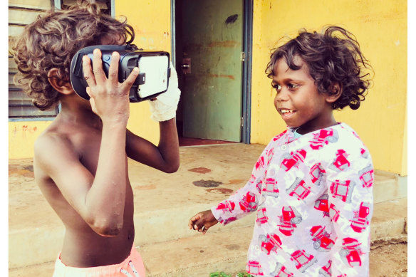 Indigenous kids play with a virtual reality headset during the making of Carriberrie, a documentary on Aboriginal dance; an image from the film with Anangu women at Uluru. 