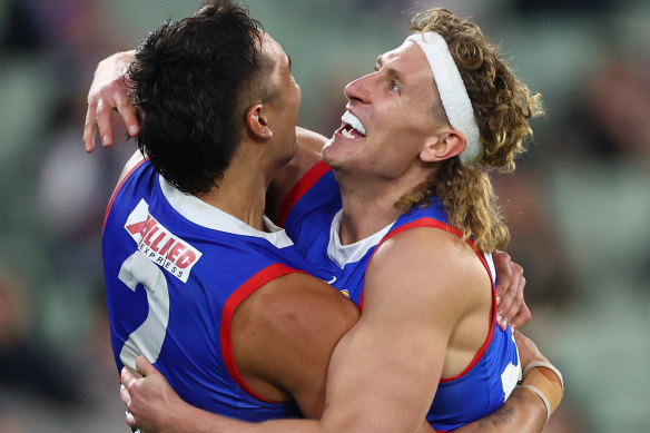 Jamarra Ugle-Hagan of the Bulldogs is congratulated by Aaron Naughton after kicking a goal.