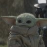 An Imperial dark trooper approaches Grogu in Lucasfilm’s The Mandalorian, season two. 