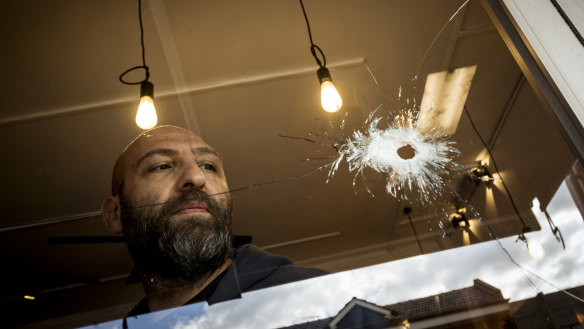 Cafe owner Fidel Takla surveys the bullet holes at his cafe.