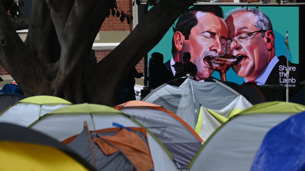 A billboard ad featuring Mark McGowan goes by ‘tent city’ in Fremantle as the camp is closed and homeless people are bussed to temporary hotel accommodation. 