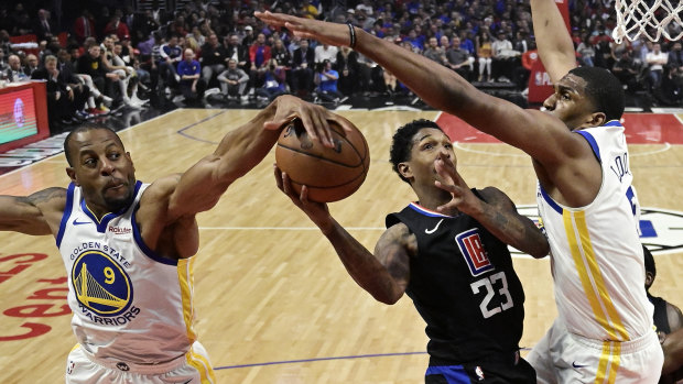 Denied: LA Clippers guard Lou Williams shoots as Golden State's Andre Iguodala and Kevon Looney apply strong defence.