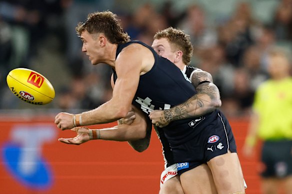 Beau McCreery tackles Patrick Cripps in a tackle. 