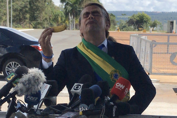 Comedian Marvio Lucio stands in front of members of the media while dressed as Brazilian President Jair Bolsonaro in Brasilia on Wednesday.