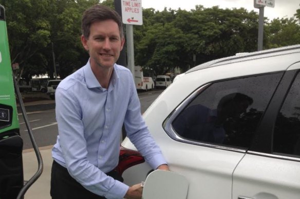 Main Roads Minister Mark Bailey charges an electric car in Cairns at the northern edge of Queensland's electric super highway.