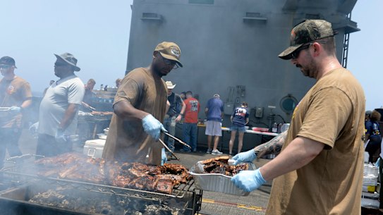 Sailors participate in a steel beach picnic on the flight deck of the aircraft carrier USS Dwight D. Eisenhower.