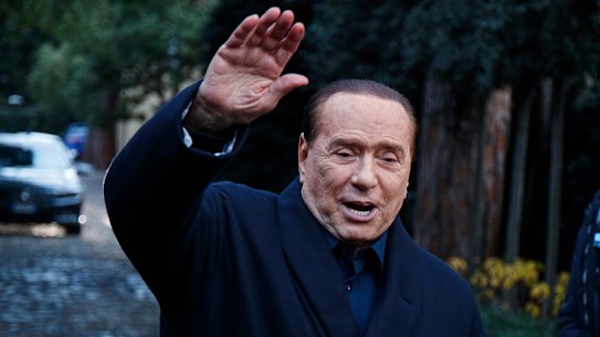 Former Italian PM Berlusconi waves to media.