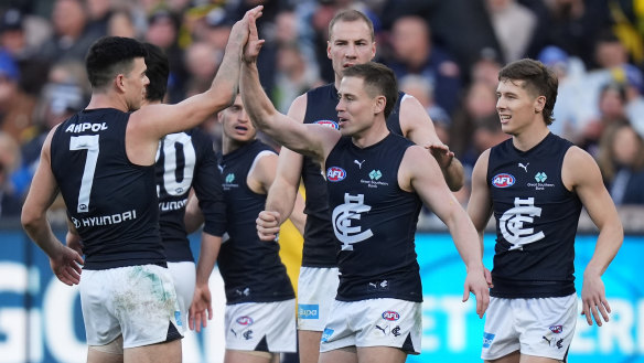Carlton players get around Matthew Owies after his goal against Richmond.