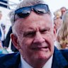 Mark Latham listens to jockey Chad Schofield while trackside at Randwick racecourse last year.