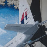 A woman walks past graffiti of the missing Malaysia Airlines Flight MH370 in Kuala Lumpur in 2016.