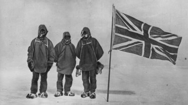 Irish explorer Sir Ernest Henry Shackleton, pictured circa 1909, with two members of his expedition team beside a Union Jack within 180 kilometres of the South Pole, a record feat. 