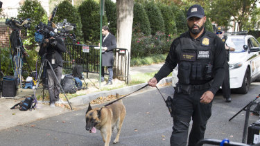 An officer with the Uniform Division of the United States Secret Service uses his dog to search a checkpoint near the home of President Barack Obama.