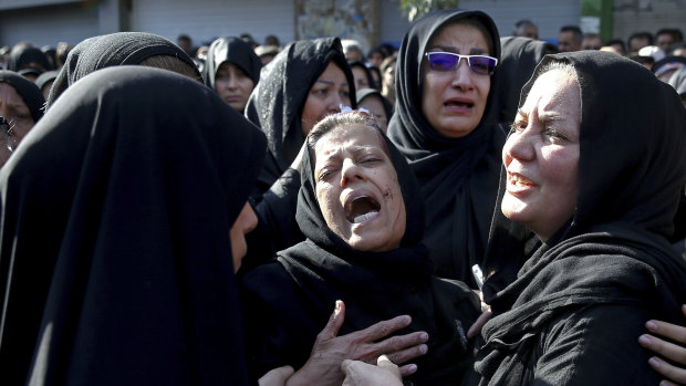 Families of victims of Saturday's terror attack on a military parade in the southwestern city of Ahvaz, that killed 25 people mourn at a mass funeral ceremony, in Ahvaz, Iran.