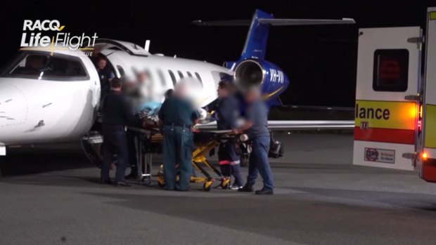 One of the injured miners lands at Brisbane Airport. All five suffered upper torso and airway burns.