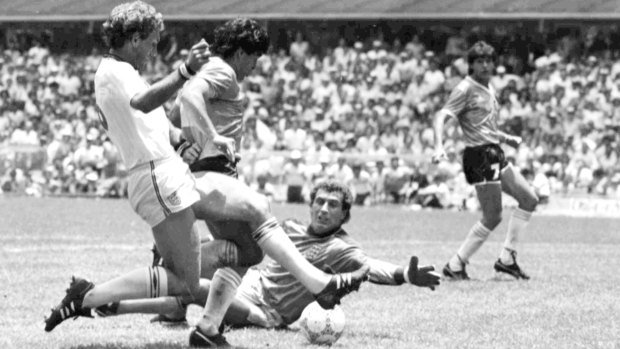 Diego Maradona (second left) is about to score his second goal against England. England's Terry Butcher (left) tries to tackle Maradona, while England's goalkeeper Peter Shilton is on the ground.