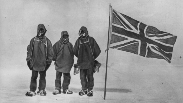 Irish explorer Sir Ernest Henry Shackleton, pictured circa 1909, with two members of his expedition team beside a Union Jack within 180 kilometres of the South Pole, a record feat. 