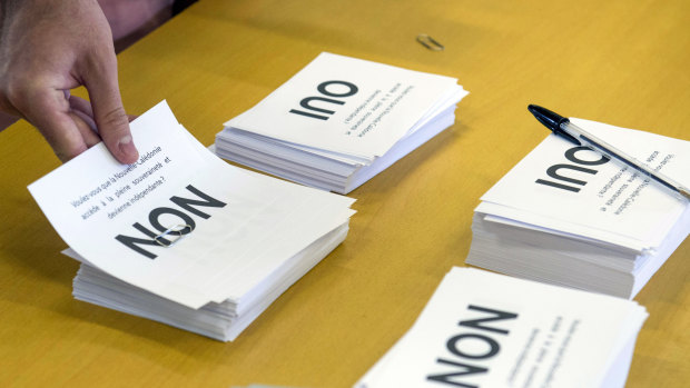 A man prepares to cast his vote at a polling station in Noumea, New Caledonia.