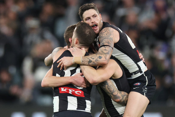 Jack Crisp (R) hugs Magpies Jeremy Howe, Brayden Maynard and Will Hoskin-Elliott on the final siren.