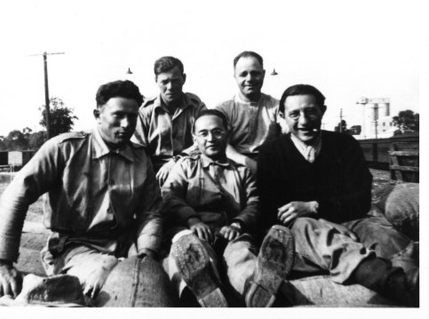 Saul Factor (bottom right) and fellow members of 6th Employment Company sitting on a pile of hessian sacks at Tocumwal, 1943. 
