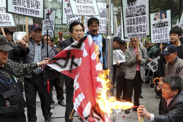 Protesters burn a Japanese rising sun flag in front of the Japanese embassy in Seoul, South Korea, in 2013.
