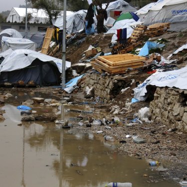 A refugee stands next to a pool of mud at a refugee camp on the eastern Greek island of Lesbos.