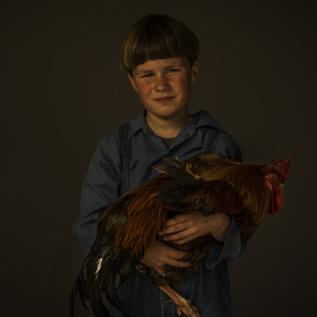 Caleb, 7, with a rooster.