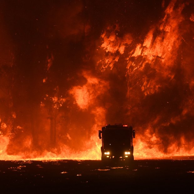 Firefighters overwhelmed by flames at a bushfire in Orangeville, west of Campbelltown.