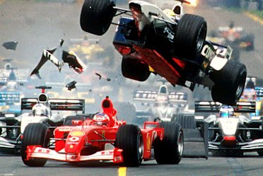 Williams team driver Ralf Schumacher from Germany flies through the air over the top of Ferrari driver Rubens Barrichello of Brazil at the start of the Australian Formula One Grand Prix in Melbourne March 3, 2002. Ferrari team driver Michael Schumacher from Germany won the race ahead of Williams team driver Juan Pablo Montoya from Colombia and McLaren team driver Kimi Raikkonen from Finland third. REUTERS/Joe Mann ***FOR EDITORIAL USE ONLY***