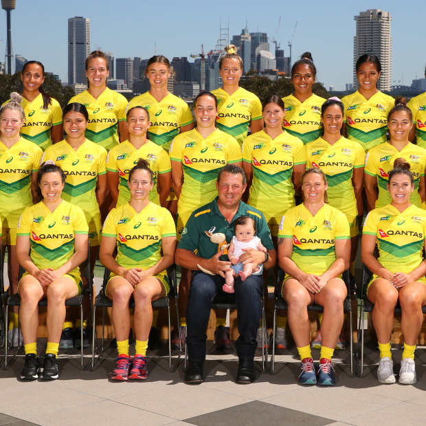 The Australian women's sevens team, with Emilee Cherry's daughter Alice sitting on the coach's knee.