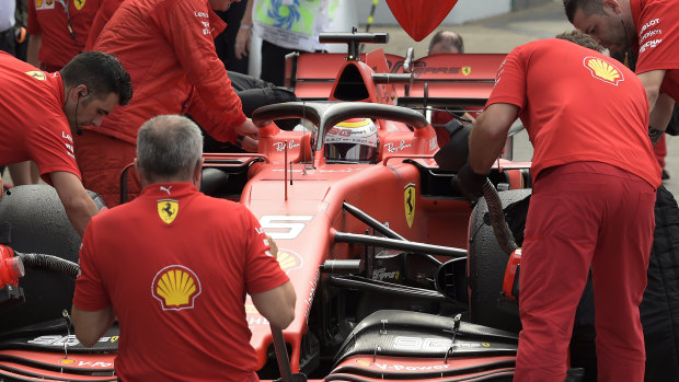 Pit crew works on the car of Ferrari driver Sebastian Vettel.