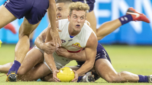 Mitch Wallis is tackled by Freo's Stephen Hill.