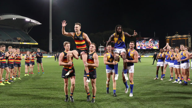 Brodie Smith of the Crows and Nic Naitanui of the Eagles get chaired off after their 200th games.