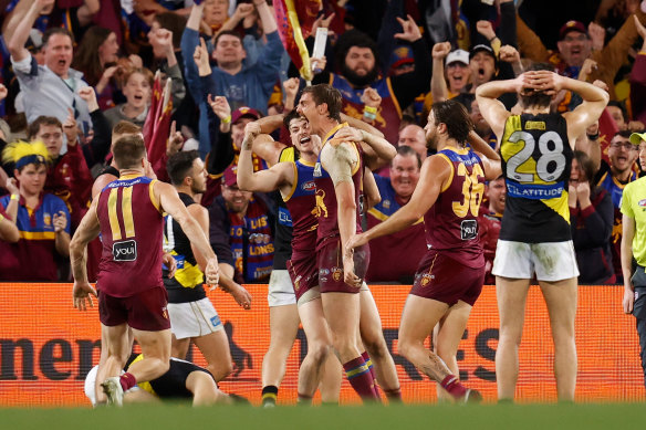 Joe Daniher celebrates with Lions teammates as he puts his side up with a minute to go.