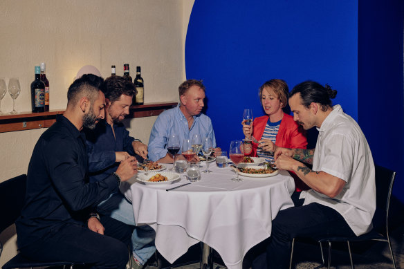 The restaurant owners in front of the feature wall.