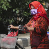 A police officer stands guard at a coronavirus check point in Jakarta.