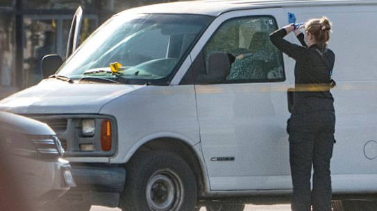 A forensic photographer gets ready to take pictures of a van’s window and its contents in Torrance, California.