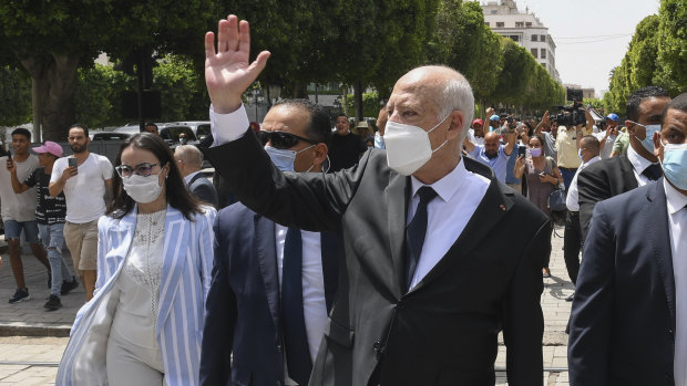 Tunisian President Kais Saied waves to bystanders as he stroll along the avenue Bourguiba in Tunis, Tunisia.