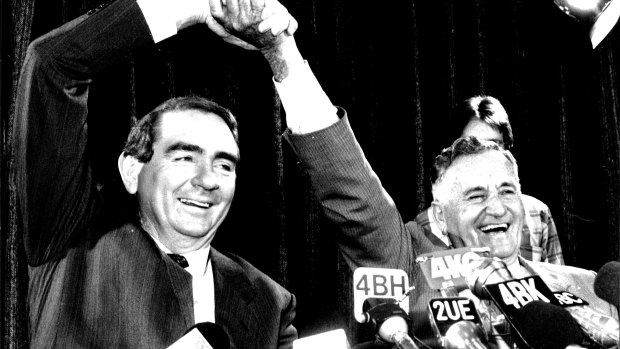 Mike Ahern and his deputy Bill Gunn give a victory salute in Mr Ahern's first press conference as premier.