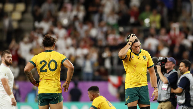 Burden of defeat: The Wallabies reel after their heavy quarter-final loss to England.
