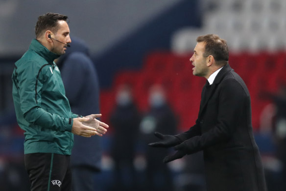 Basaksehir's manager Okan Buruk (right) reacts to fourth referee Sebastian Coltescu.