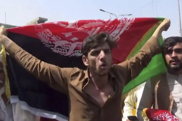 A man holds the Afghan flag during a protest in Jalalabad on Wednesday.